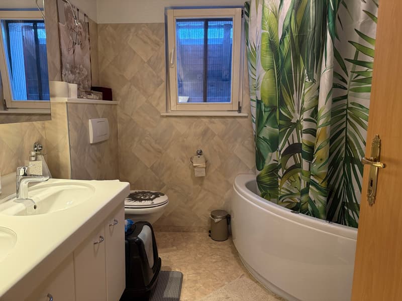 Bathroom with bathtub, sink, toilet, and window