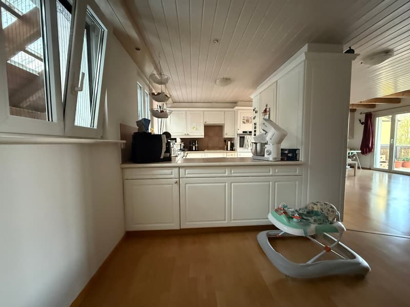 modern kitchen with white cabinets, wooden floor, large windows, kitchen appliances, baby walker