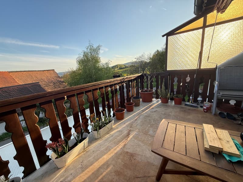 wooden railing, wooden table, wooden bench, potted plants, view of the landscape