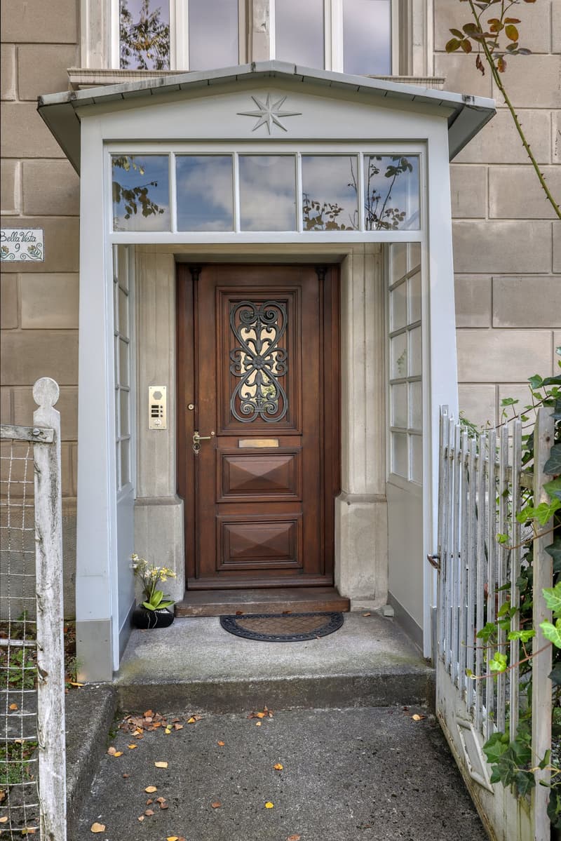 wooden door, white entrance, glass windows, small flower pot, ivy plant
