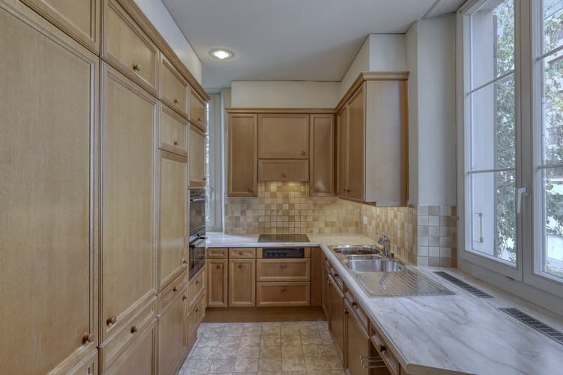 modern kitchen with wooden cabinets, marble countertop, double sink, oven, dishwasher, tiled floor