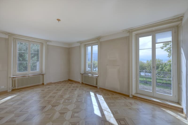 empty room, wooden parquet floor, large windows, balcony, radiators, white walls