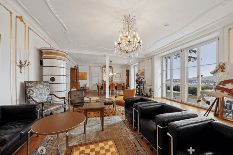 modern furniture, white walls, chandelier, wooden floor, fireplace, glass doors, view to the outside