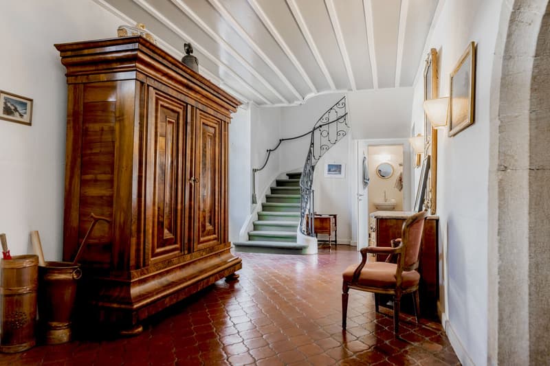 Wooden cabinet, vintage chair, hallway with staircase, tiled floor, picture frames