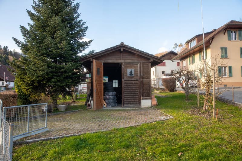 Wooden structure with a slanted roof, a large door and a window