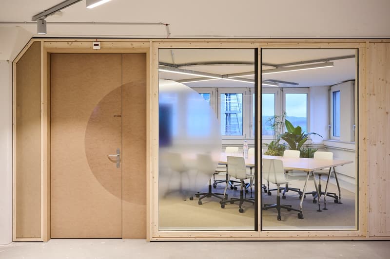 conference room with office chairs, table, glass walls, plants