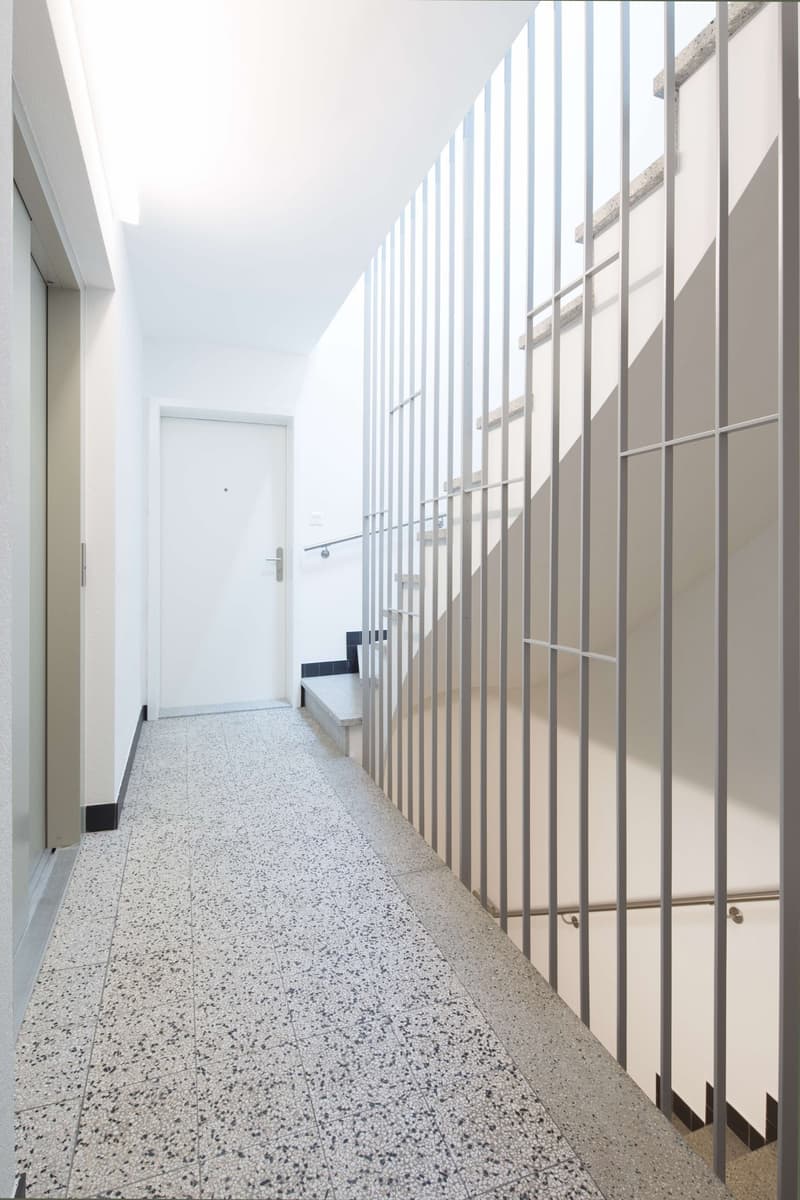 modern design, concrete floor, steel railing, white walls, white door, staircase