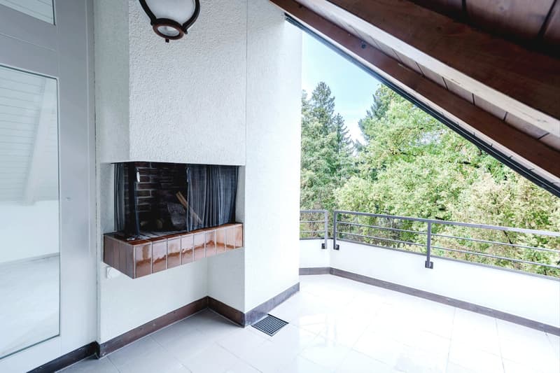 white tiles, fireplace in the wall, balcony with metal railings, skylight