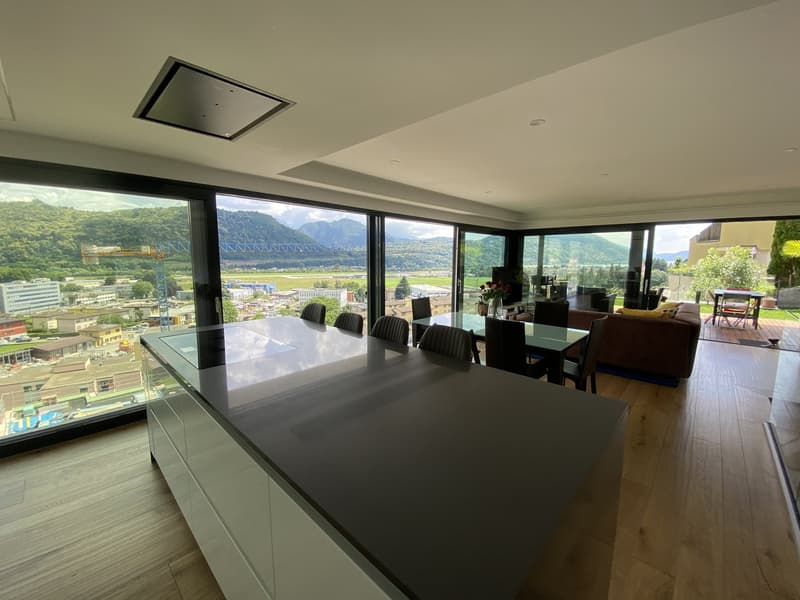 large kitchen with island, dining table, large windows, view of mountains and city