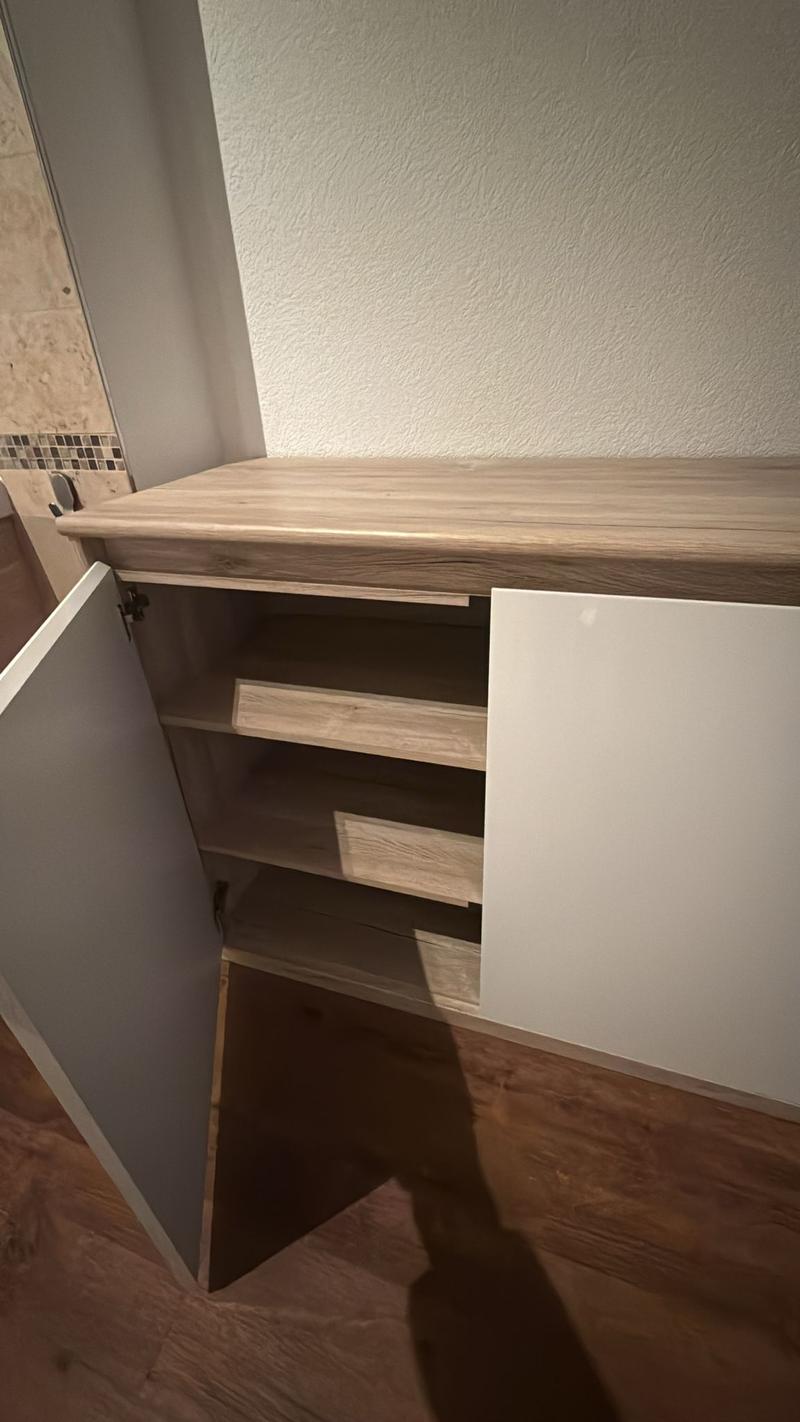 Built-in wooden cabinet with sliding doors and multiple shelves
