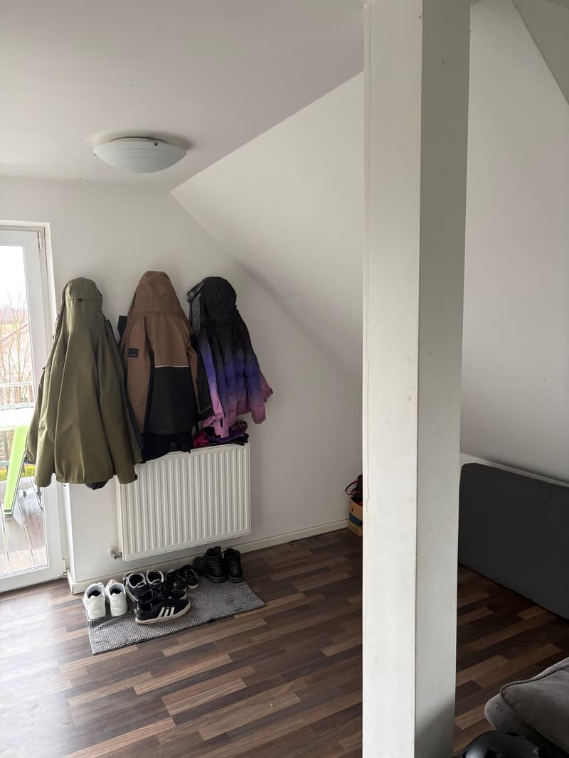 A room with a wardrobe, shoes, and a radiator
