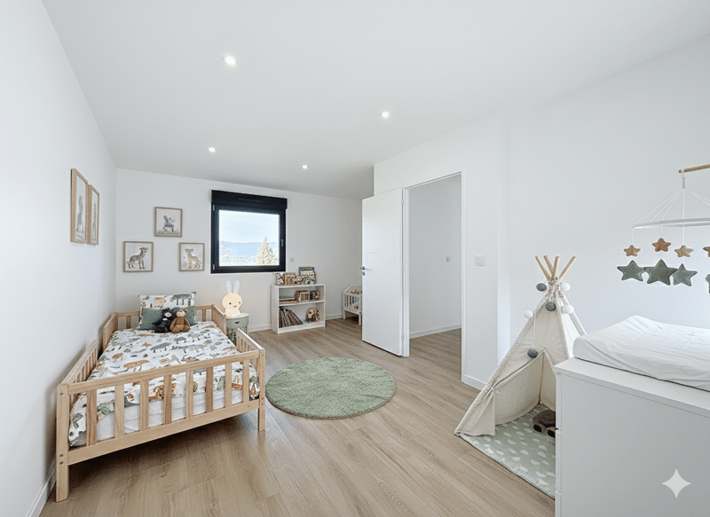 Children's room with wooden bed, rug, and toys, white walls, open door leading to play area, shelves with books, white canopy bed, crib, green decorative pillows, wooden wall decorations, stars hanging from ceiling.