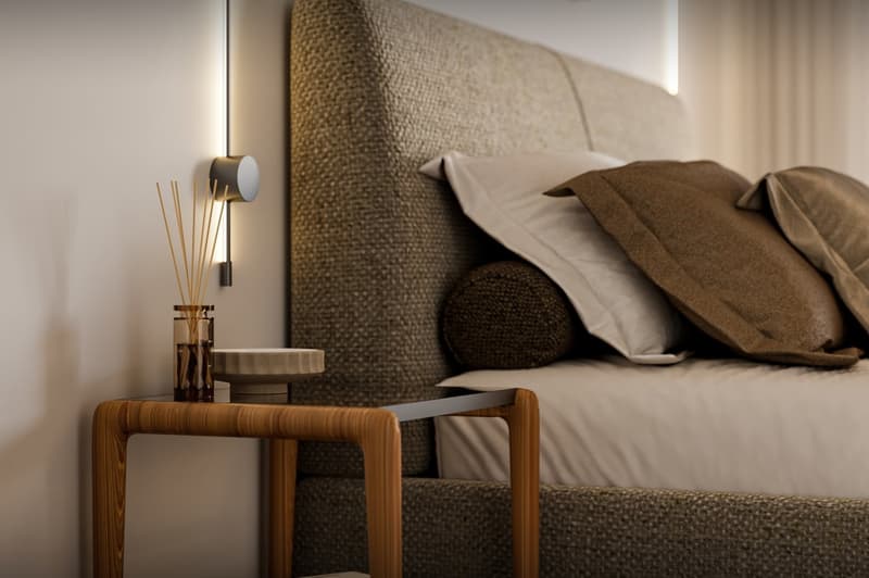 Bed with pillows, nightstand with a glass jar and a bowl, wall lamp