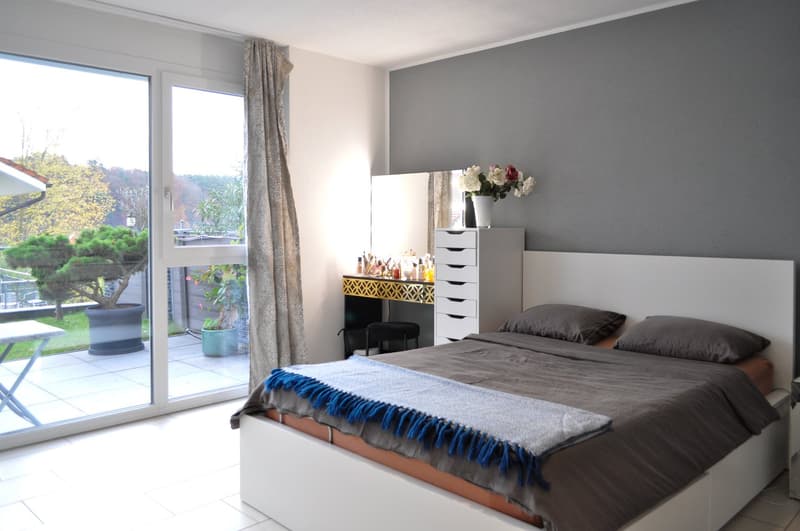 double bed, bedside tables, floor-to-ceiling sliding glass doors, plants, trees, greenery