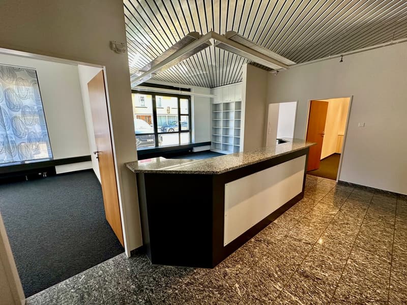 empty room, reception desk, carpeted floor, marble floor, large window, shelves