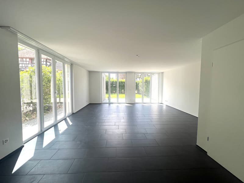 empty room, white walls, black tiled floor, large glass doors, balcony, garden view