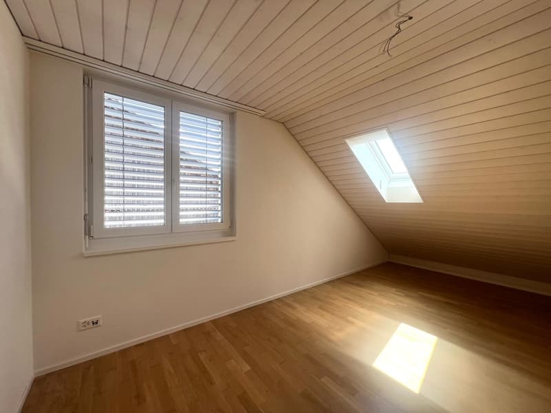 empty room, wooden floor, white walls, two windows, one with shutters, one skylight