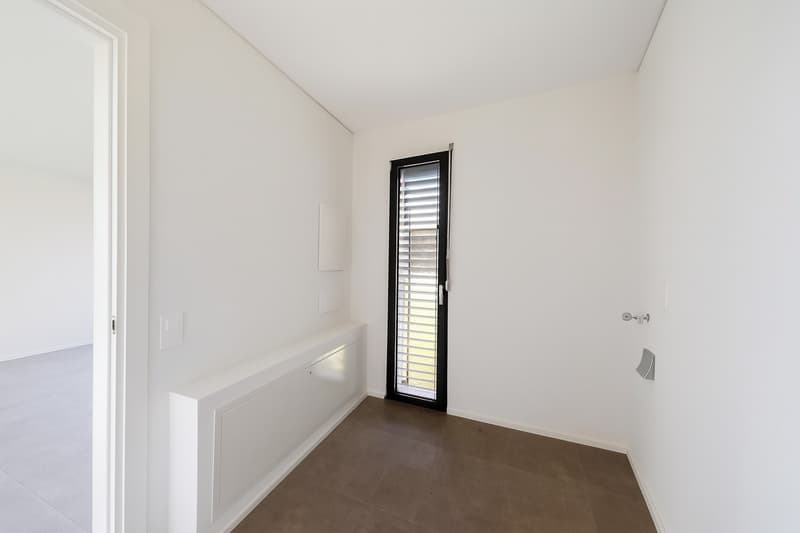 empty room, white walls, brown tile flooring, closed door, window with blinds