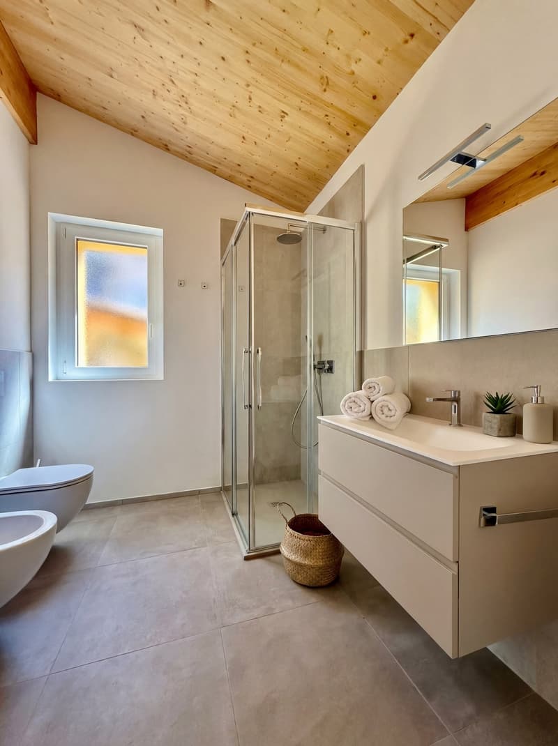modern bathroom with wooden ceiling, separate shower cubicle, glass partition, sink, and mirror