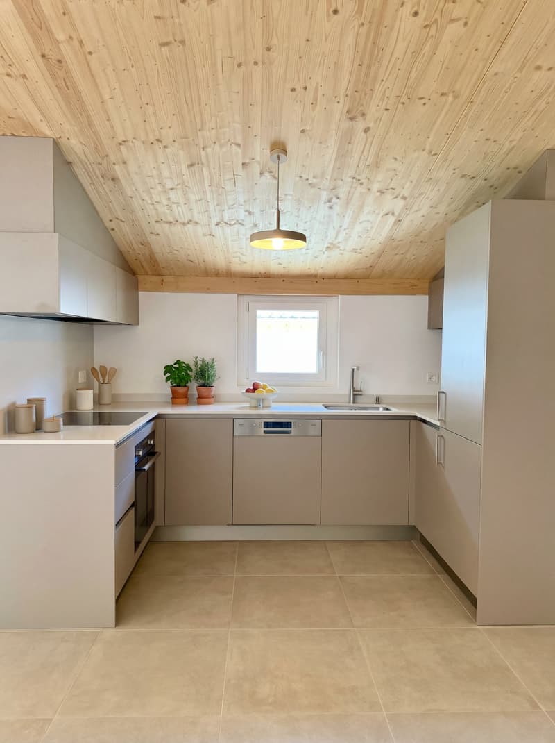 Modern kitchen with tile flooring, white cabinets, built-in appliances, ceiling fan, plants, and a window