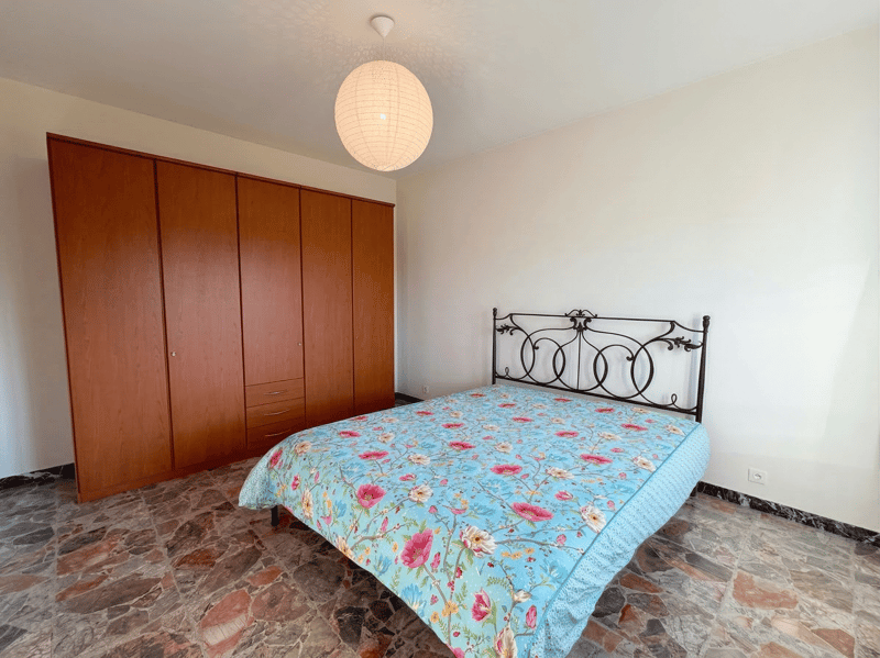 bedroom with bed, wardrobe, and stone floor