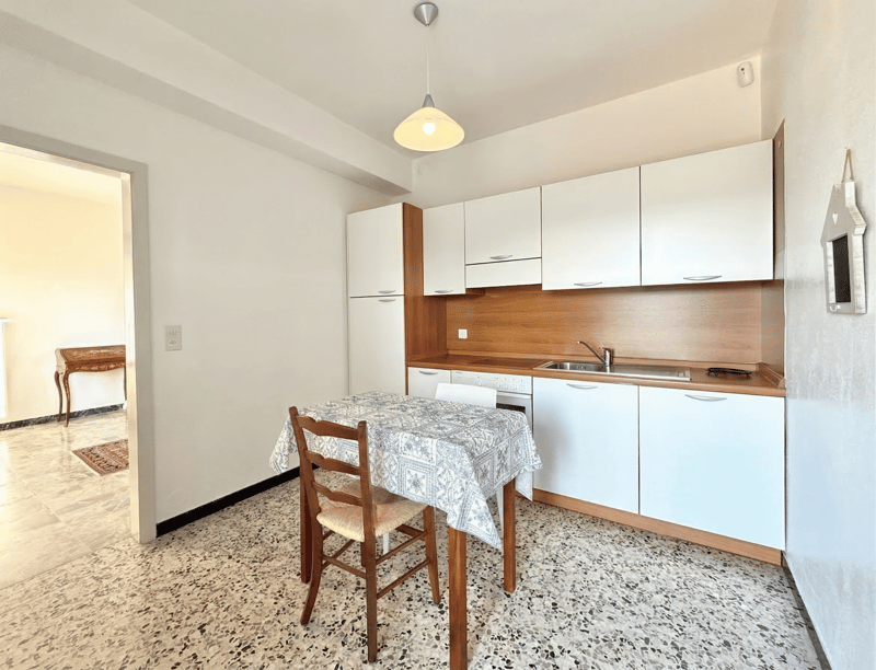 modern kitchen with white cabinets, wooden dining table, white tiled floor, pendant light