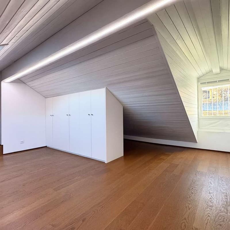Empty room with wooden floor, white walls, white ceiling, built-in wardrobe, window