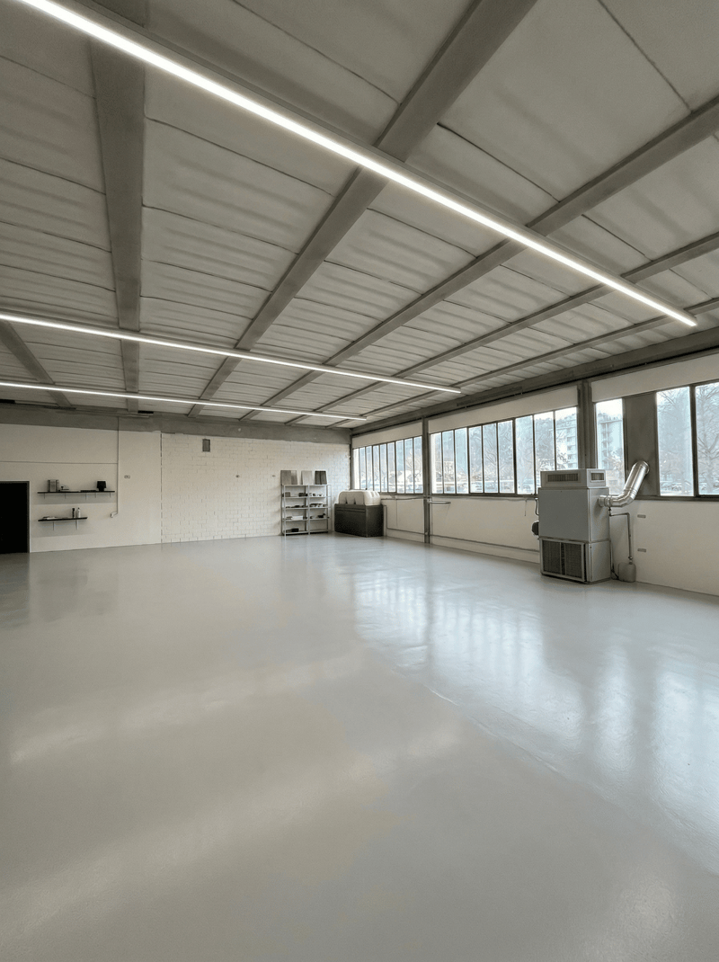 spacious room, white walls, white floor, large windows, metal shelves, air conditioning unit