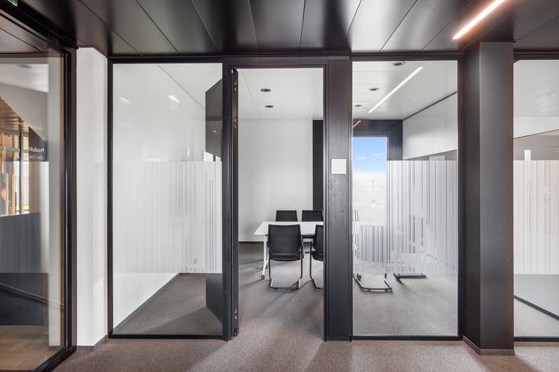 modern glass wall office space, with white wall and floor, glass door with blinds, a table, and chairs