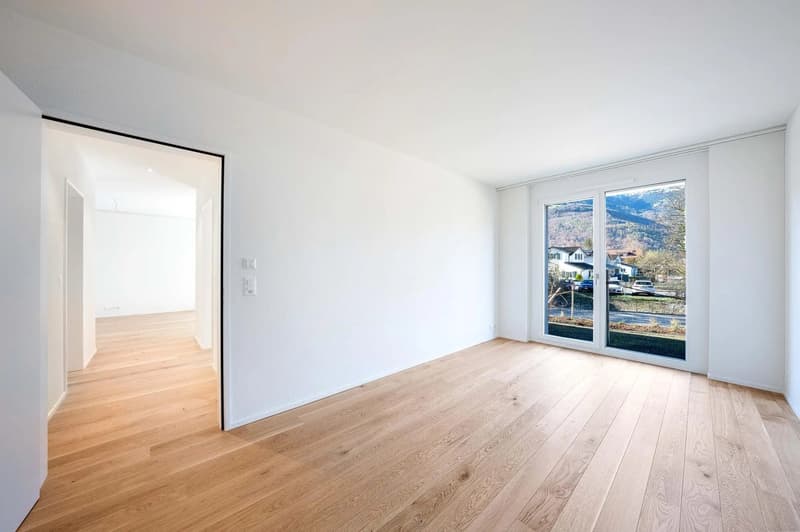 empty room, hardwood floors, large sliding glass doors, two light switches on wall