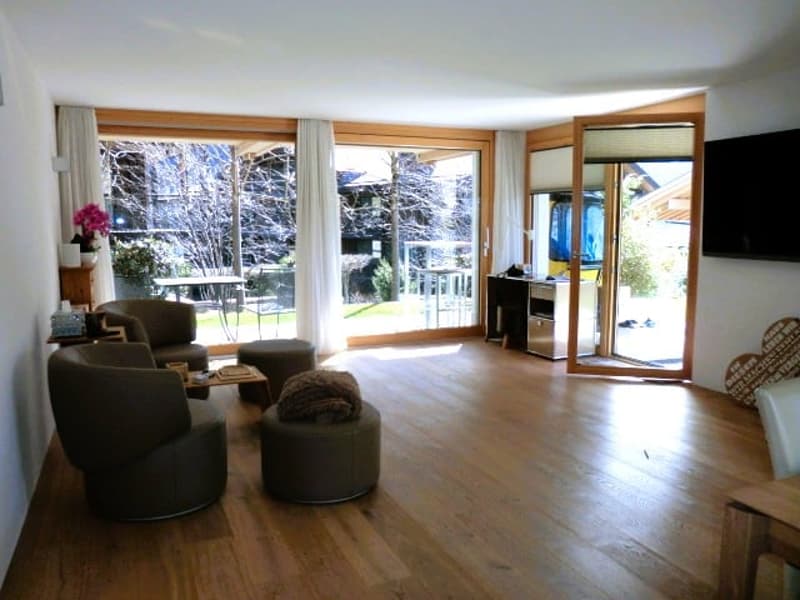 wooden floor, large windows, balcony, chairs, ottoman, table, TV