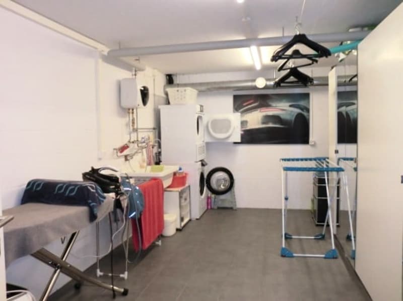 Laundry room with washing machine, dryer, ironing board, and drying rack