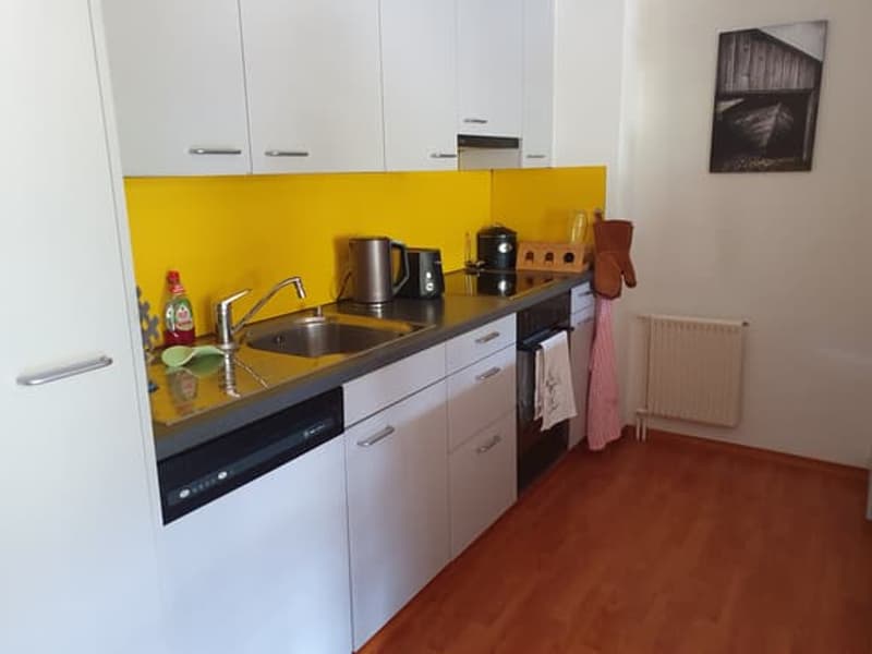 kitchen with white cabinets, yellow wall, gas stove, oven, sink, dishwasher, coffee machine, microwave, toaster