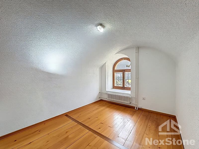 empty room, wooden floor, white walls, arched window, white radiator, ceiling light