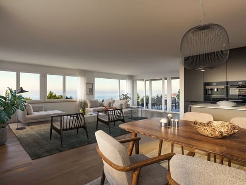 modern living room with large windows, wooden table, comfortable seating, and a view of the ocean