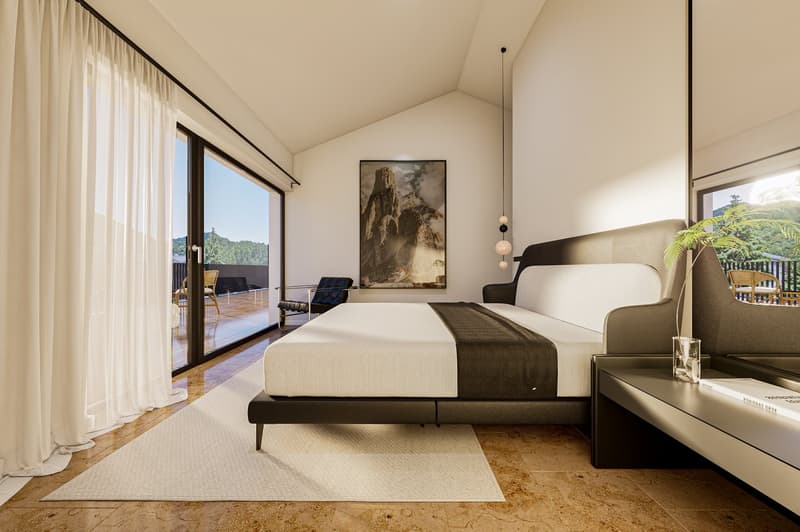 modern bedroom with a large bed, white walls, large windows, balcony, and a view of the mountains