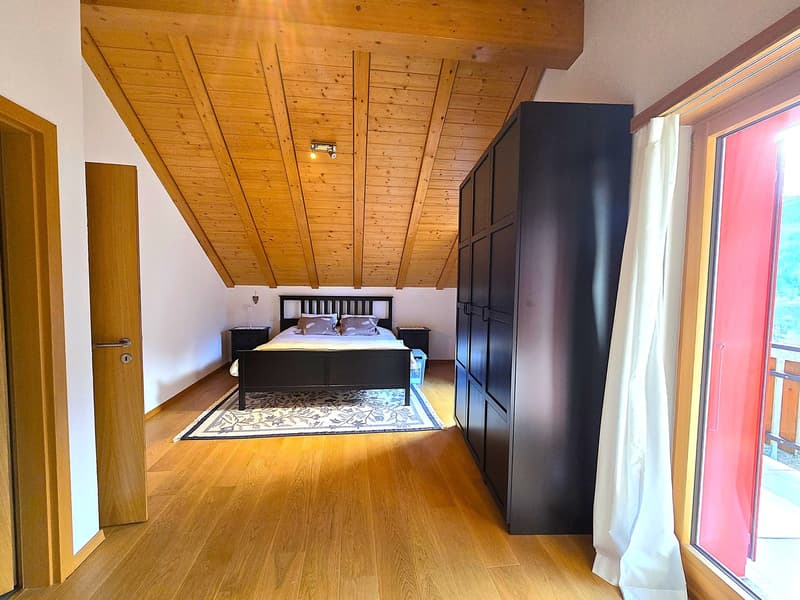 bedroom with wooden floor, wooden ceiling, bed, nightstands, wardrobe, rug, balcony