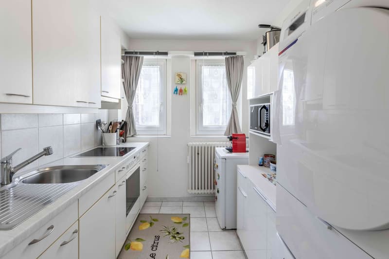 fully equipped kitchen with stainless steel sink, oven, dishwasher, fridge, microwave, kitchen cabinets, window, radiator