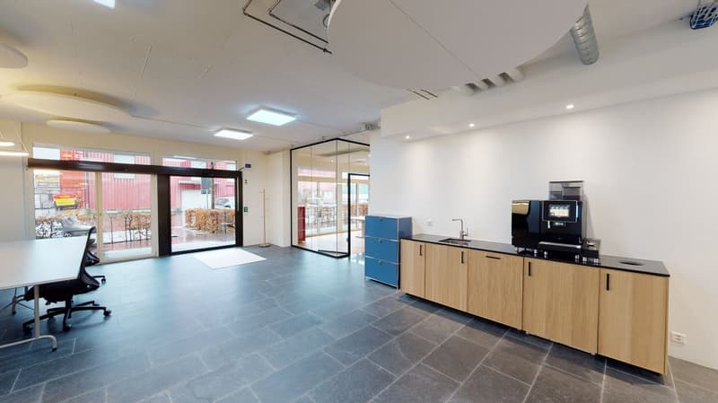 modern office room, glass doors, large windows, tiled floor, wooden cabinets, black countertop, office chair, desk, coffee machine