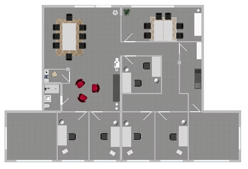 Open floor plan with multiple desks, meeting room, kitchen area, and a central large table