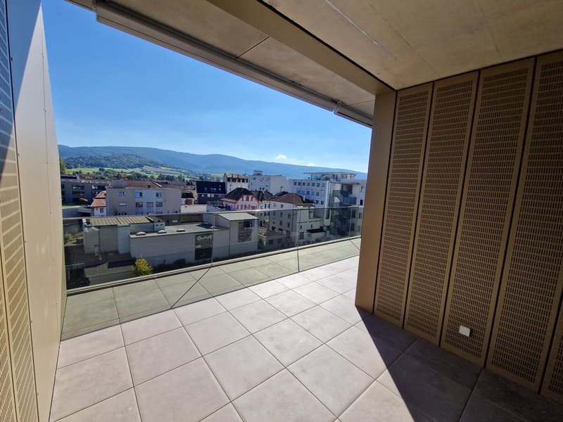 Balcony with tiled floor, glass railing, view of the city and mountains