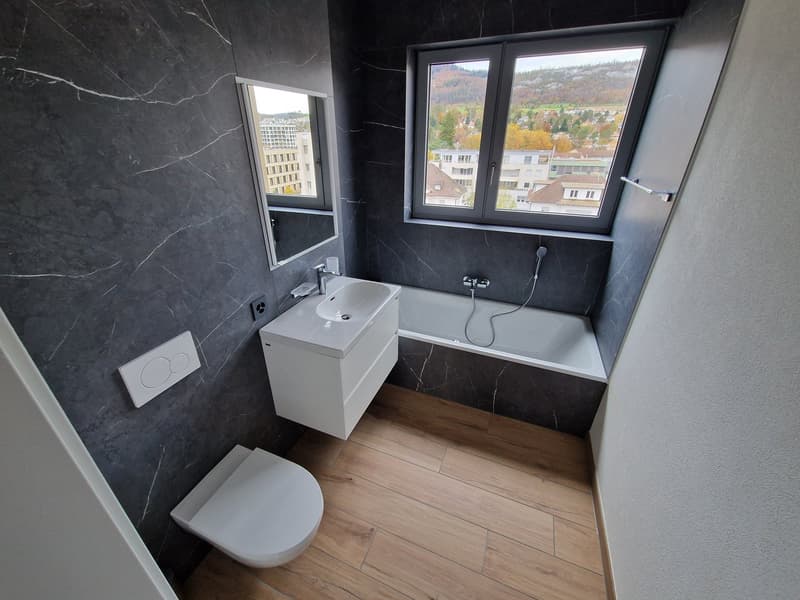 modern bathroom with marble walls, white toilet, white sink, bathtub, window