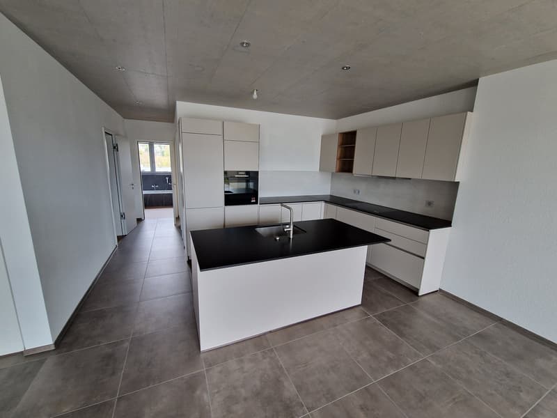 modern kitchen with white cabinets, black countertops, stainless steel faucet, tiled floor, open layout