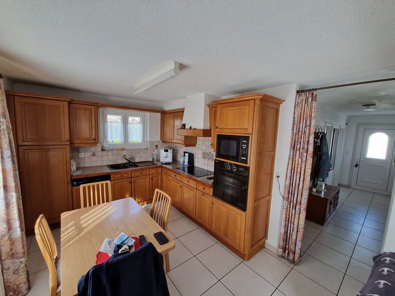 kitchen with wooden cabinets, tiled floor, dining table, sink, oven, microwave, dishwasher, washing machine