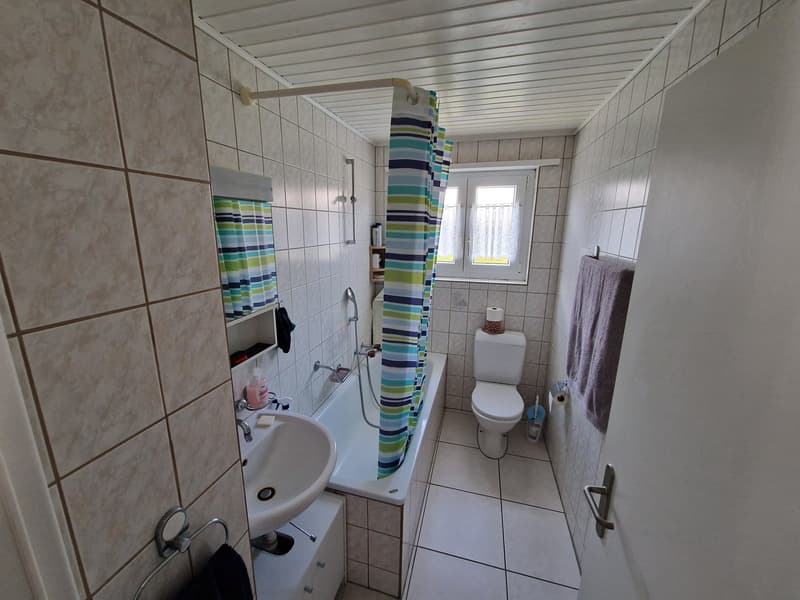 Bathroom with bathtub, sink, toilet, and window