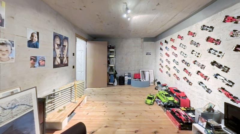 wooden floor, wall with pictures, shelves, toy cars, radiators, door