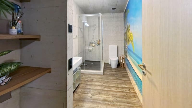 Bathroom with shower, toilet, sink, wooden floor, wall shelves, decorative items, beach mural