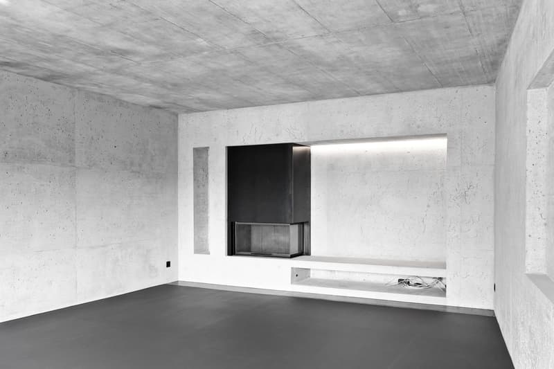 concrete walls, black floor, fireplace, built-in bench, modern design