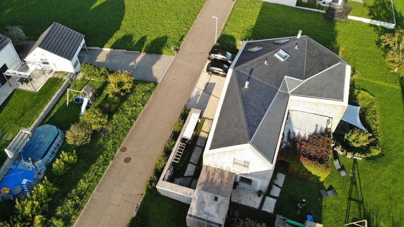 Modern house, gray roof, swimming pool, 3 cars parked, green lawn, garden, aerial view