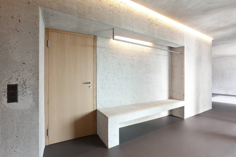 Concrete walls, wooden door, concrete bench, built-in lighting